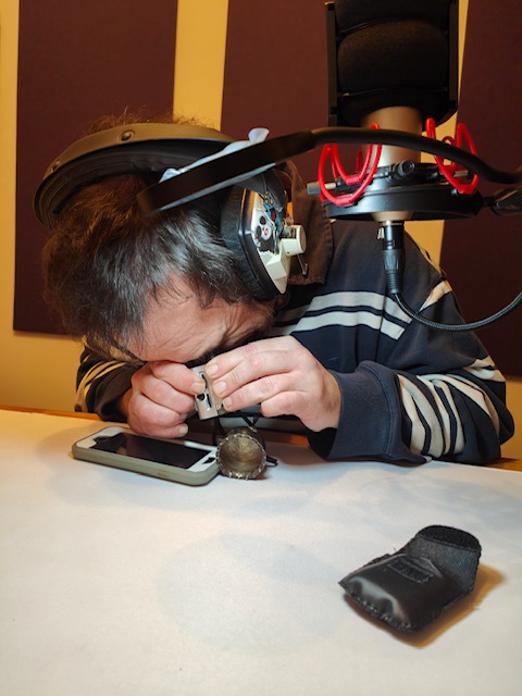 Adam tries to examine the tiny sterling silver cauldron through the microscope