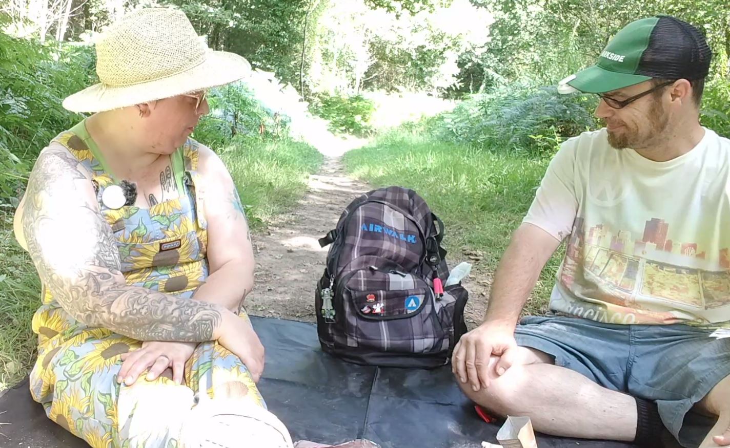 Karen and Adam admire Adam's tat item - his rucksack, after showing off the hotwheels bottle opener, pinbadges and ligher on a retractable cord carabiner